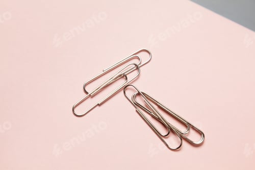 Preview: metal paper clips and paper on paper background