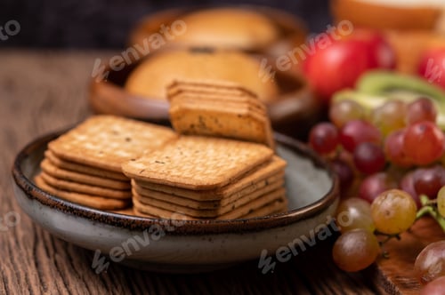 Preview: Breakfast consists of bread, apples, grapes and kiwi on a wooden table.
