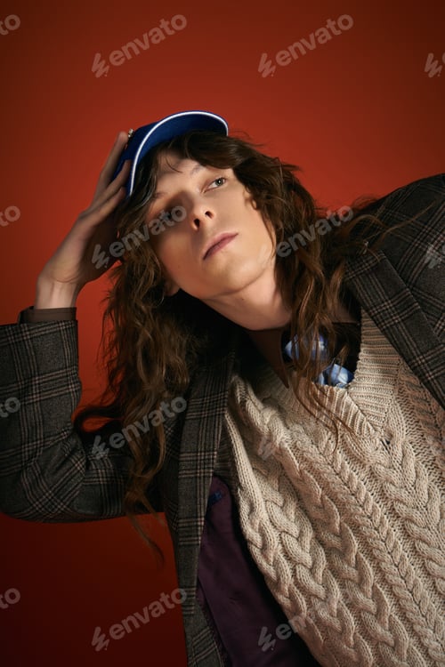 Preview: Stylish young man showcasing trendy fashion in a vibrant studio setting