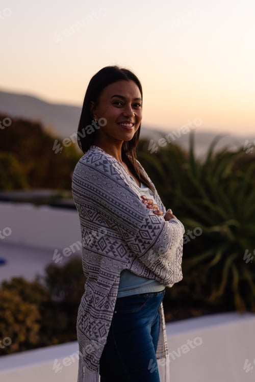 Preview: Portrait of happy biracial woman in garden at sunset