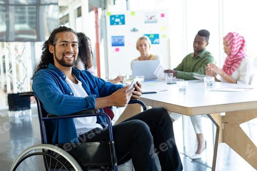 Preview: Disabled businessman with digital tablet looking at camera in conference room during meeting