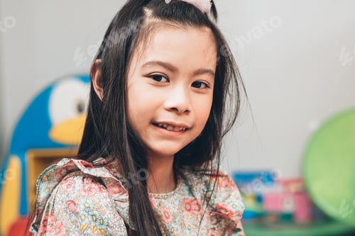 Preview: Asian girl smiling and looking at camera.