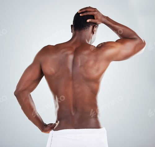 Preview: Rear view of one African American fitness model posing topless in a towel and looking muscular. Bla