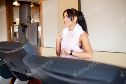 Preview: Healthy sporty woman doing cardio exercise on treadmill.