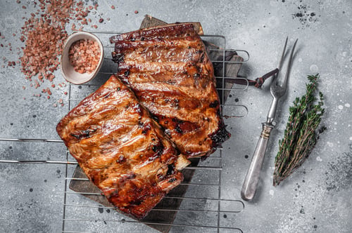 Preview: BBQ grilled pork ribs in Barbecue sauce on a grill. Gray background. Top view. Copy space