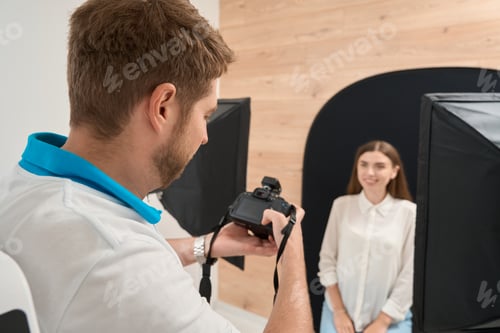 Preview: Dentist photographing joyous patient using digital camera
