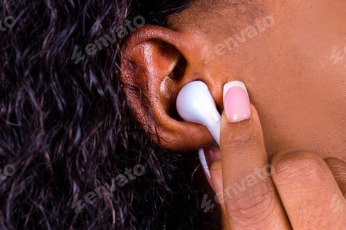Preview: african american woman isolated on blue background in studio Listen music with earpods