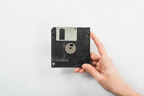 Preview: partial view of man holding black diskette on white background