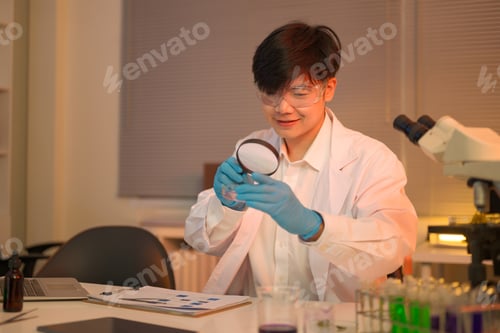 Preview: Scientist examines a liquid sample in a petri dish with a magnifying glass