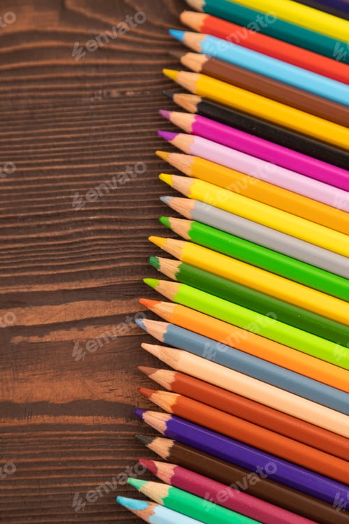 Preview: Set of watercolor pencils on brown wooden. Top view