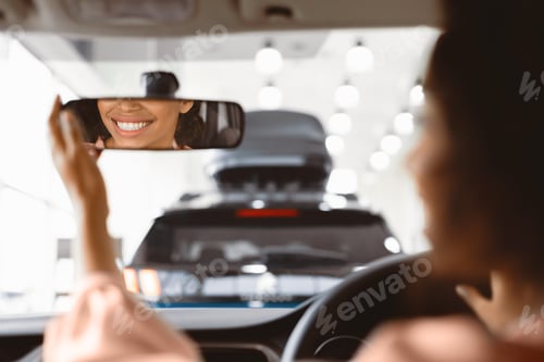 Preview: Unrecognizable Woman In Driver's Seat Checking Mirrors In Dealership Showroom