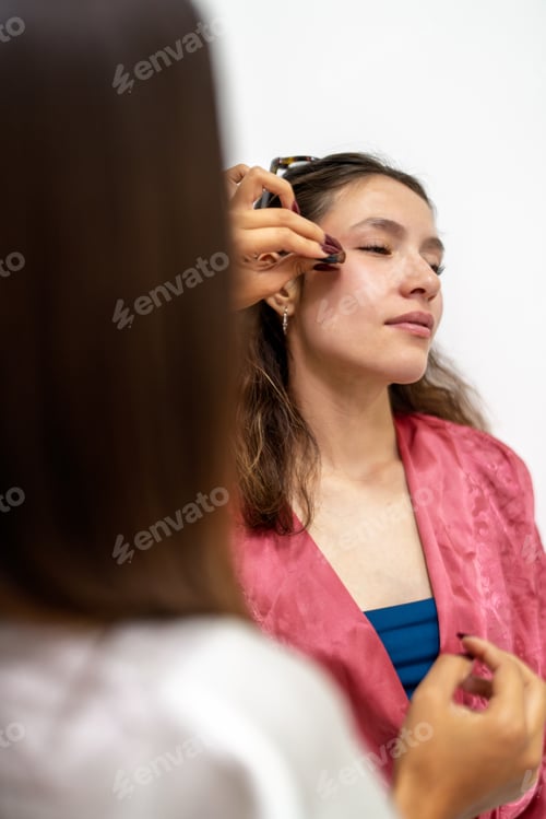 Preview: Make up artist applying make up to young woman before party
