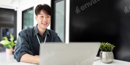 Preview: Businessman using laptop computer in office, Happy young asian businessman in modern office looking
