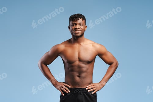 Preview: Smiling African American man, athlete with muscular body, naked torso isolated on blue background