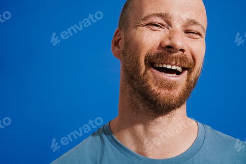 Preview: Ginger man with beard laughing and looking at camera