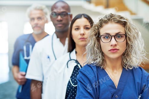 Preview: Thoughtful team of doctors looking at camera