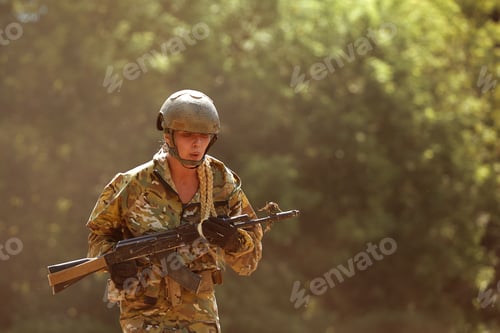 Preview: Caucasian Military lady woman in tactical gear posing for photo at summer season. Wearing green camo