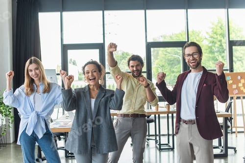 Preview: Excited multiethnic business people showing yes gesture and looking at camera in office