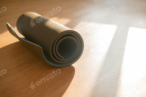 Preview: a roll of yoga mat on the wooden floor, doing exercise in the gym, sport equipment