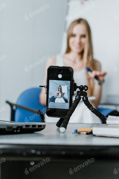 Preview: Young woman have online meeting, online courses, remote coaching, near open laptop and smartphone
