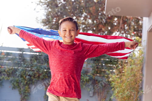 Preview: Portrait Of Proud Hispanic Boy Wrapped In Stars And Stripes American Flag Running Towards Camera