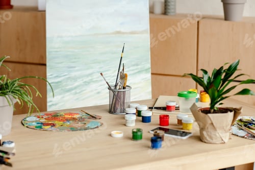 Preview: close-up view of artist workplace with paints brushes and palette in art studio