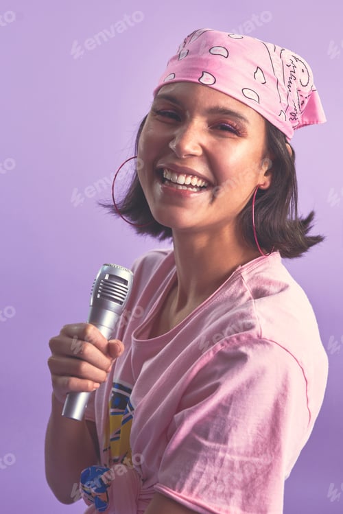 Preview: Studio shot of a beautiful young woman singing with a microphone against a purple background