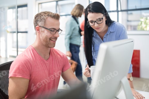Preview: Employees discussing work at their work station