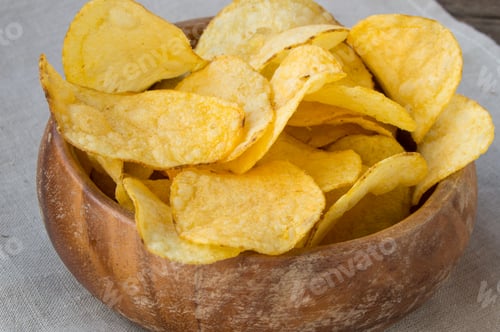 Preview: Delicious crispy potato chips in an old wooden bowl