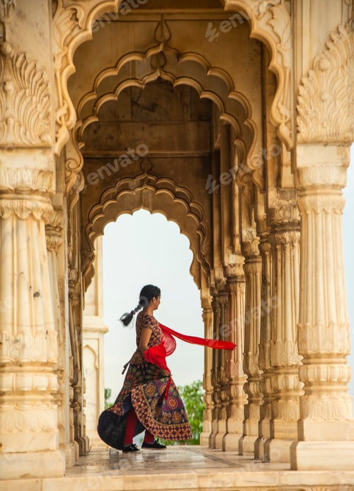 Preview: Young female tourist dancing between arches and Pillars.