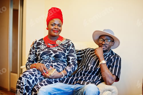 Preview: Beautiful african american woman in traditional dress and handsome black man sitting and smiling.