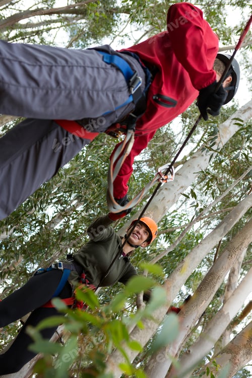 Preview: Man helping woman to cross zip line in the forest