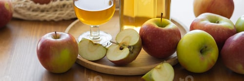 Preview: Fresh homemade organic apple juice or cider on a wooden table in a glass jug. Banner copy space