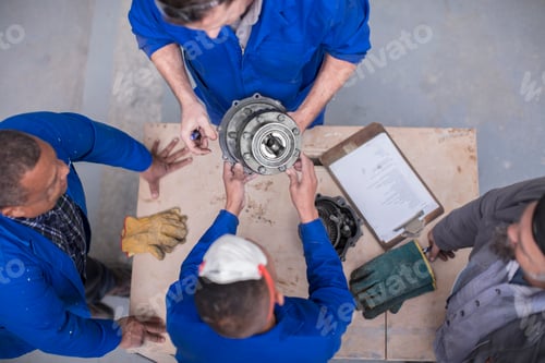 Preview: Mechanics working together on a machine part