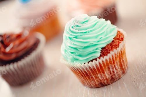 Preview: Delicious Cupcakes with Colorful Frosting on Wood Surface