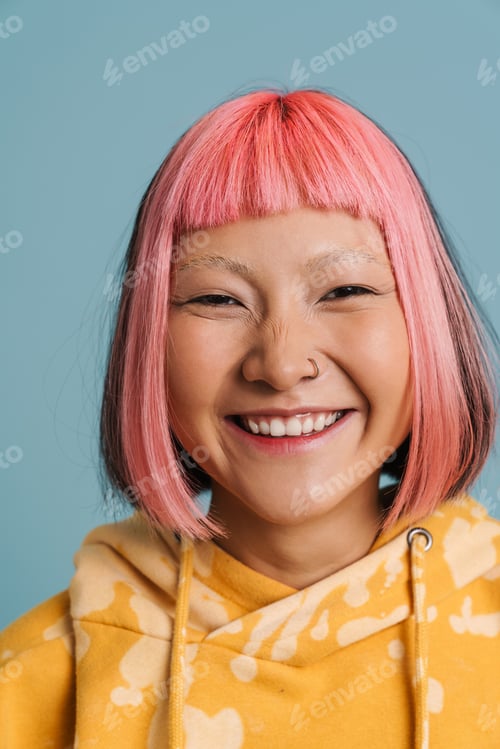 Preview: Asian girl with pink hair and piercing laughing while looking at camera