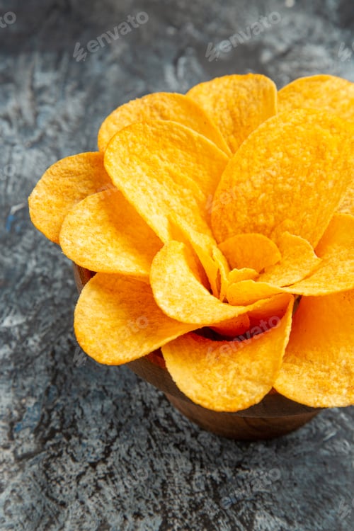 Preview: Vertical view of potato chips decorated like flower shaped in a brown bowl on gray background