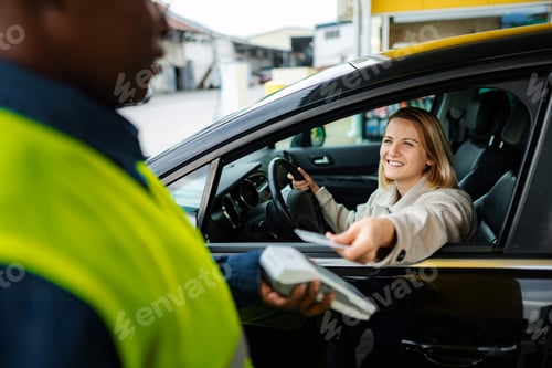 Preview: Woman paying for gas fueling car with credit card at service station