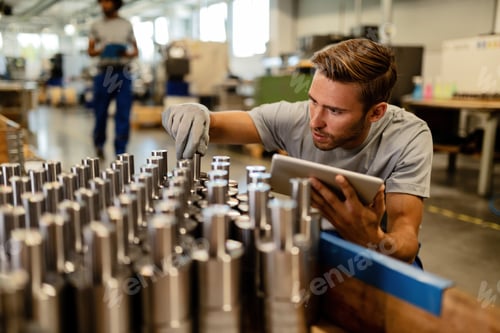 Preview: Young steel worker performing quality control of manufactured products in a warehouse.
