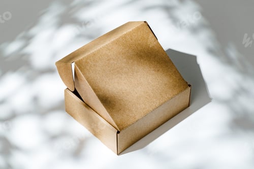 Preview: An open cardboard box rests on a bright white surface with soft shadows