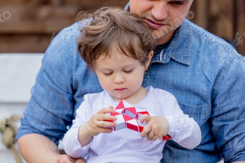 Preview: Father Watches Toddler Playing with Puzzle Toy