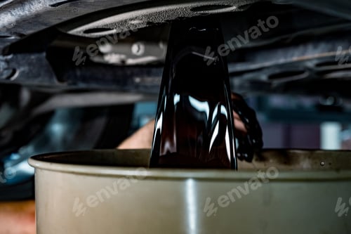 Preview: Old dirty oil pouring from the car engine in car service station close up