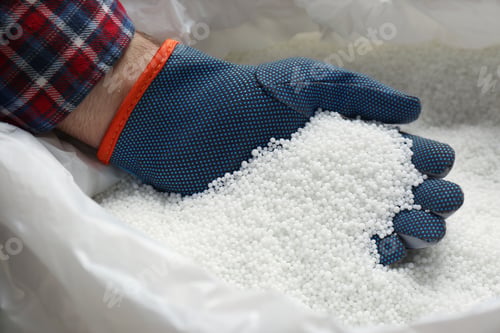 Preview: Farmer taking pellets of ammonium nitrate from bag, closeup. Mineral fertilizer