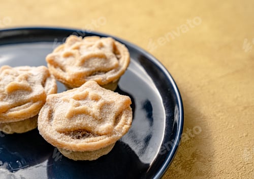 Preview: Closeup of yummy star-shaped mince pies served on a dish, a traditional Christmas dessert