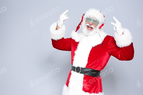 Preview: Santa Claus listening to Christmas music on color background