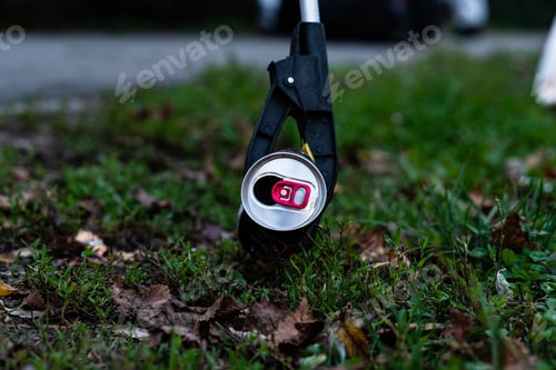 Preview: Closeup of a soda can clipped between the jaws of a trash picker