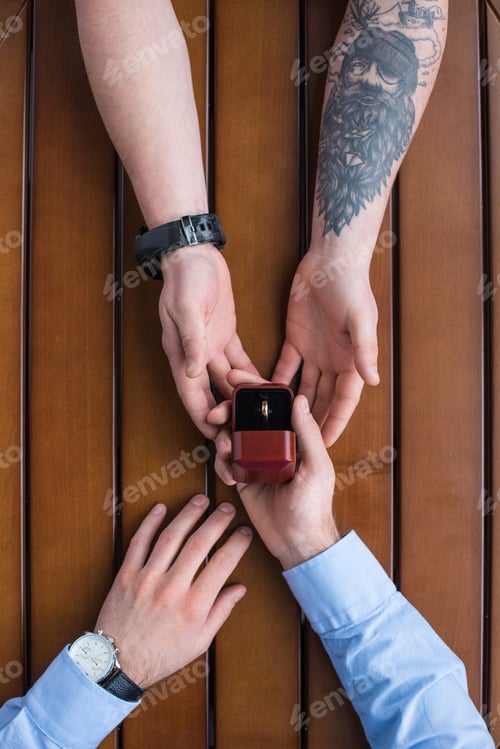 Preview: cropped image of boyfriend proposing girlfriend and holding wedding ring
