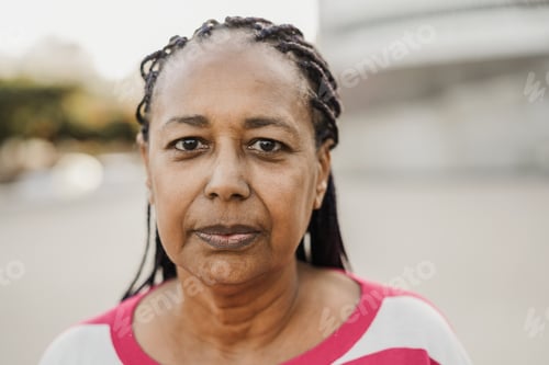 Preview: Senior african woman looking at camera outdoor in the city - Focus on face