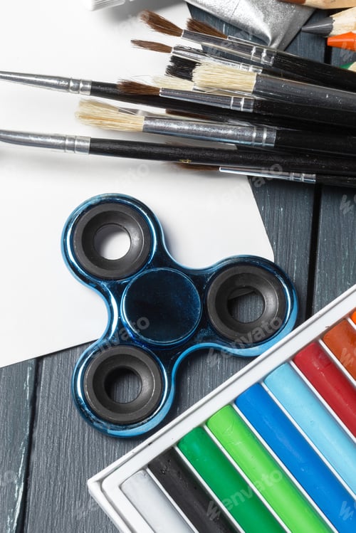 Preview: Spinner and School supplies on wooden table. close up