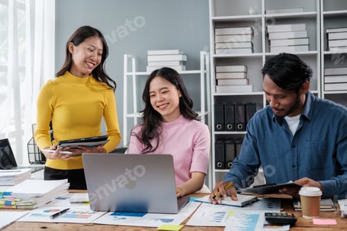 Preview: Group of young Asian business people brainstorming, looking at laptop computer.